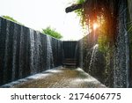 Small photo of Dam is the flowing water like a small waterfall curtain. Water overflowing the mortar weir during the rainy season with bench is under and sunlight at Pang Sawan Weir, Uthai Thani, Thailand.