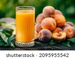Healthy breakfast - ripe peaches, croissants and glass of freshly squeezed juice on table. Vegetarian food, vitamins, summer harvest from fruit tree. High quality photo