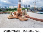Close up Air terminal rod and bare copper cable install on rooftop of high building for Lightning protection and protect electrical equipment damage when raining and lightning strike. Selective focus.