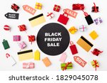 Top view of circle with black friday lettering near credit cards and toy shopping bags on white background
