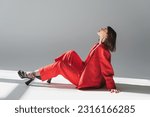 Small photo of full length, side view, young brunette woman with short hair posing in suit on grey background, generation z, trendy outfit, fashionable model, professional attire, executive style, heeled shoes