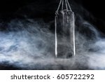 Black punching bag in empty room filled with smoke  isolated on black
