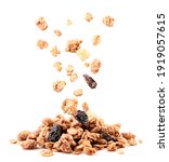 Crispy granola with raisins and banana falling on a heap close-up on a white background. Isolated