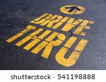 yellow drive thru sign on black asphalt
bright sunlight, 