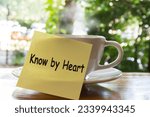 Small photo of Paper note word know by heart On Purpose the hot coffee cup on table background. Example of know by heart concept. top view.by heart