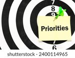 Small photo of Dart board game target of PRIORITY on paper note background. PRIORITIES and business important planning urgency concept.