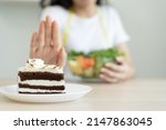Small photo of eat less sugar for health, women avoid to eat chocolate cake and sweets during sugar diet session for lose weight