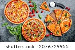 Small photo of Top dow flat lay view on pizzas with fresh eco ingridients on rustic background, Pizza shop table