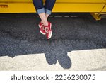 woman sitting on a yellow car in red shoes 