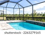 Modern contemporary home villa with screened in glass canopy lanai private pool with view of tropical lake in Florida with blue water in clean house