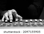 close up sound engineer hands adjusting control surface mixer in recording, broadcasting studio