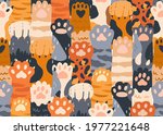 Seamless pattern with cute cat paws raised up together. Repeating background with kitties