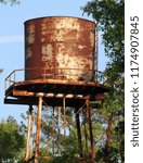 Small photo of Old Rusty Water Tower in Slidell, Louisiana near an old trading post building from the late 1800s. Early Spanish and French settlers and Native American Indians used a nearby cottage as a trading post