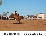 A cowboy competing in a bull riding event at an Australian country rodeo