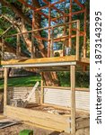 Small photo of The timber frame for a children's cubby house above a sand pit