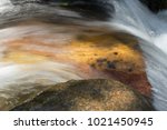 Water Flowing Over Orange Stone