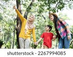 Diversity of young women and a child walk in the forest. travel with children. LGBTQ family. Family enjoying outdoor activities in the forest
