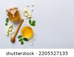 Small photo of honey jar with acacia flowers and leaves. fresh honey top view flat lay.