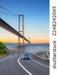 Small photo of Cars in motion in the highway landscape under the Bosphorus bridge. Road landscape at colorful sunset. Car driving on the road. Nature scenery on city beach. Travel journey for summer trip on road.