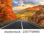 Black asphalt road landscape at sunset in beautiful colorful nature. Highway scenery among mountains in autumn season. Nature landscape on beautiful road in colorful fall. Autumn landscape in Germany.
