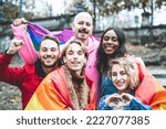 Young activist for lgbt rights with rainbow flag, group of diverse people of gay and lesbian community, heart shape hands, smiling and happy faces