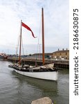 Small photo of LOWESTOFT, SUFFOLK, UK – JULY 30, 2022: Historic smack LT.64 GLEANOR heads through the Inner Harbour at Lowestoft during the International Smack Race Festival.