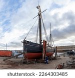 Small photo of LOWESTOFT, SUFFOLK, UK – FEBRUARY 19, 2023: LT.472 Excelsior, a traditional Lowestoft fishing smack built in the town in 1921 to trawl the southern North Sea, on the slipway undergoing overhaul.