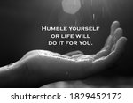 Inspirational quote - Humble yourself or life will do it for you. With open arm hand receiving the light on black and white abstract art background. 