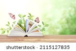 Small photo of Book of nature. Horizontal banner with book open and two Monarch butterflies on wood table. Knowledge, education, ecology and environment concept. Copy space for text