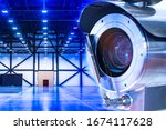 Small photo of Video surveillance at an industrial enterprise. The video camera captures what is happening in the room around the clock. Installation of a video surveillance system in a warehouse.