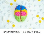 The brain is surrounded by pills. Useful neurological medications. Treatment of brain diseases. Nootropic drugs. Memory improvement. The 3D model of the brain is on a white background. Neurology.