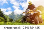 Small photo of Man on quad bike. Tourist travels on ATV. Guy is into extreme racing. Quad bike driver in yellow helmet. ATV bike race. Man with ATV in picturesque place. Extreme rider rides off-road