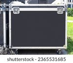 Small photo of Cases for musical equipment. Boxes with sound instruments. Cases for audio equipment on grass. Boxes for transportation of concert technique. Cases with musical equipment on wheels. Protective box