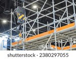 Small photo of Lifting hook at moment of lifting load. Rigging near mezzanine in hangar. Lifting hook for cargo work. Construction equipment. Rigging hook for moving heavy objects. Construction background