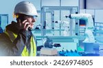 Small photo of Man in high-tech production facility with robots. Industrial specialist makes phone call. Hand manipulator and industrialist. Man factory engineer calls contractor. Worker servicing industrial robots