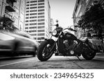 Small photo of Chicago, Illinois, USA - July 3, 2023: Traffic passes an Indian Scout motorcycle parked on the side of the street.