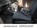 Small photo of Employee cleaning car with portable vacuum cleaner