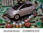 Small photo of Toy car on motherboard cpu socket. The shortage of semiconductors creates a shortage of new cars. Conceptual image for semiconductor shortage disrupting production of the automotive industry.