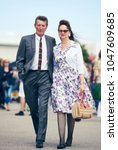 Small photo of london, England, 05/05/2017, A stylish retro vintage teddy boy elvis style 1950s fashionable man with a quiff with a woman walking at a vintage event..