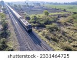 Small photo of Pune, India - March 26 2023: Passenger Train hauled by a WAP4 loco heads towards Pune, at Kamshet near Pune India.