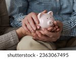 Small photo of Saving money investment for future. Senior adult mature couple hands holding piggy bank with money coin. Old man woman counting saving money planning retirement budget. Investment banking concept