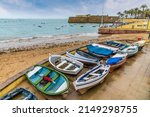 A view of boats beside the beach near to the castle in the city of Cadiz on a spring day