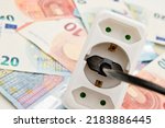 Power plug on euro banknotes. Cost of electricity and expensive energy concepts. Increasing consumption, energy crisis. Inflation. Price level are getting more expensive annually.