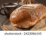 Close-up of a loaf of freshly baked homemade bread on the table. Whole-grain white bread. Healthy food, bread on sourdough. Close-up.