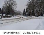 Snowy and uncleared country road in winter, risk of accident in road traffic due to slippery conditions,entrance to the town