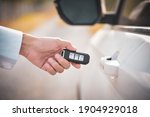 Car remote control by smart key, Hand holding smart key to lock doors of white car