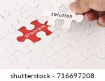 Management concept with hand holding piece of jigsaw puzzle with problem and solution wording