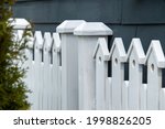 A White Wooden Fence With Two...