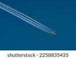 four engine jet aricraft with contrail on a blue sky