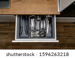 Opened kitchen drawer with Stainless steel cutlery set